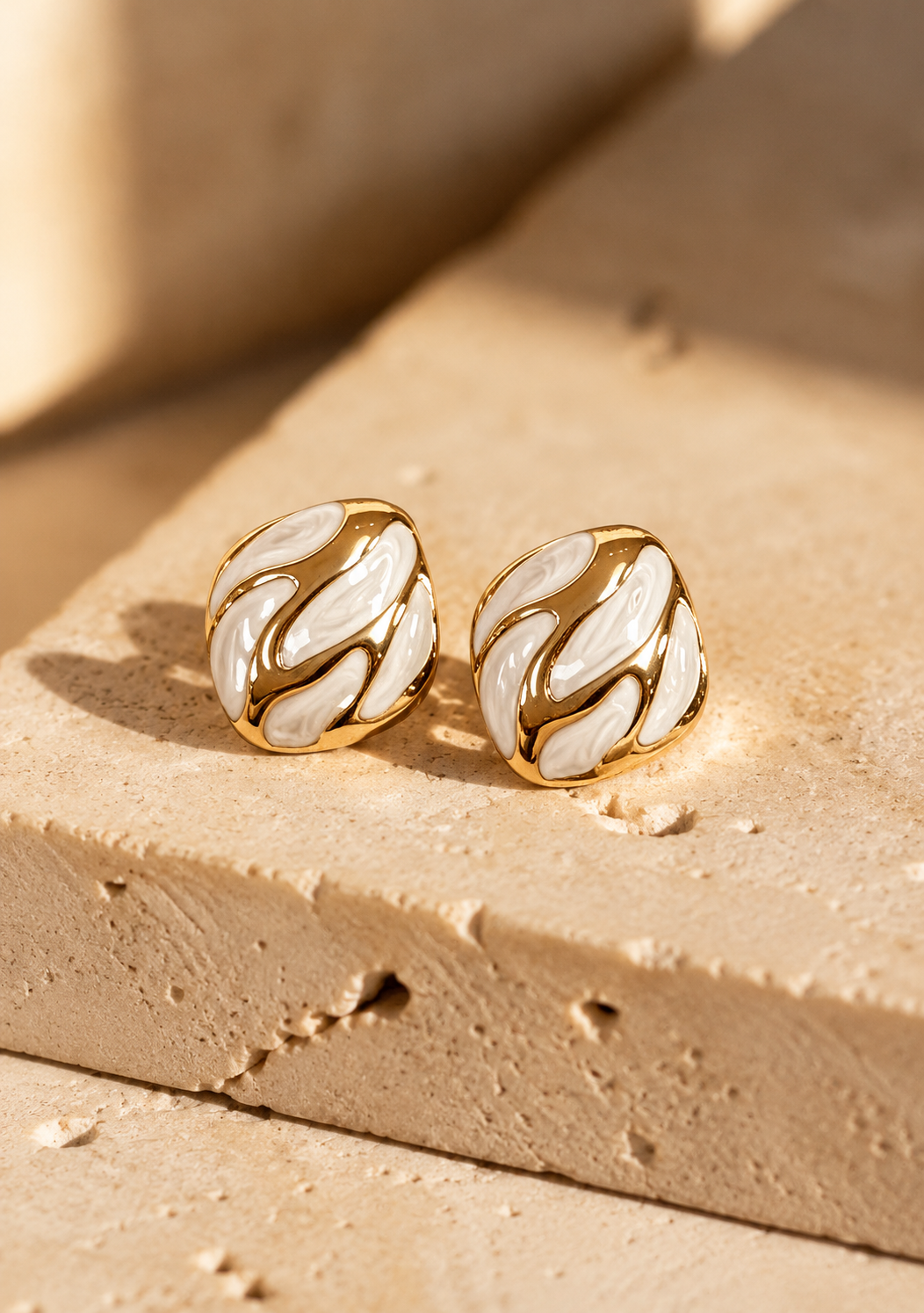 Swirl gold stud earrings with creamy white enamel swirl by Salt & Tide Co