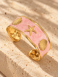 Beachcomber wide gold cuff with blush pink enamel, golden shells and starfish by Salt & Tide Co