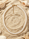 Sandbar shell necklace in creamy white glass beads with gold tone clasp by Salt & Tide Co