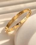 Lucky Clover 18K gold plated stainless steel bangle with sparkling clover details by Salt & Tide Co