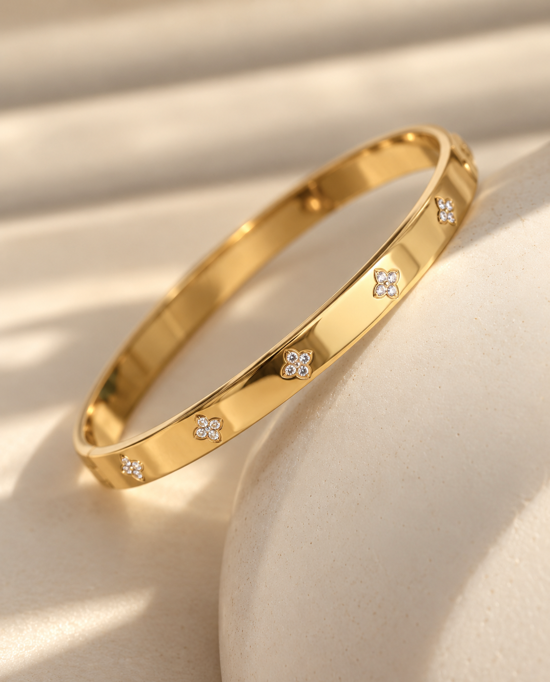 Lucky Clover 18K gold plated stainless steel bangle with sparkling clover details by Salt & Tide Co